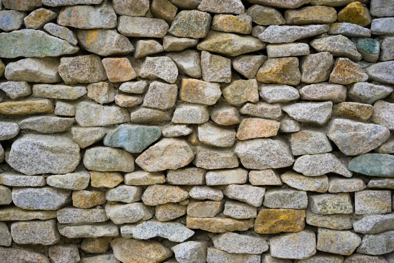 Mixed natural rock retaining wall for landscape terracing by MCG Top Masonry
