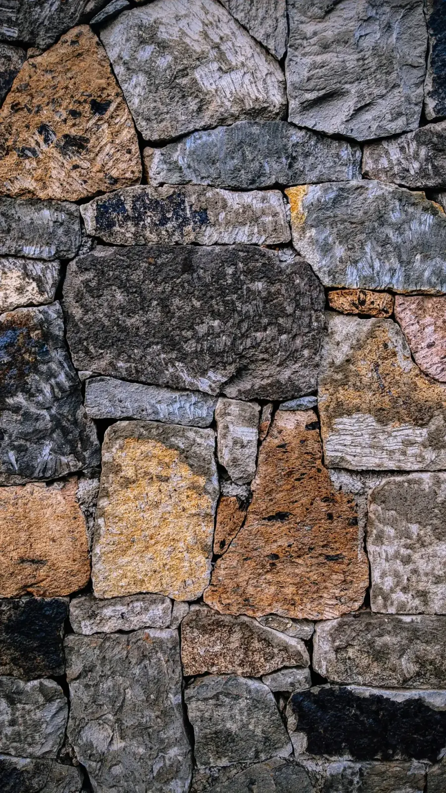 Gray and black stacked stone retaining wall built by MCG Top Masonry