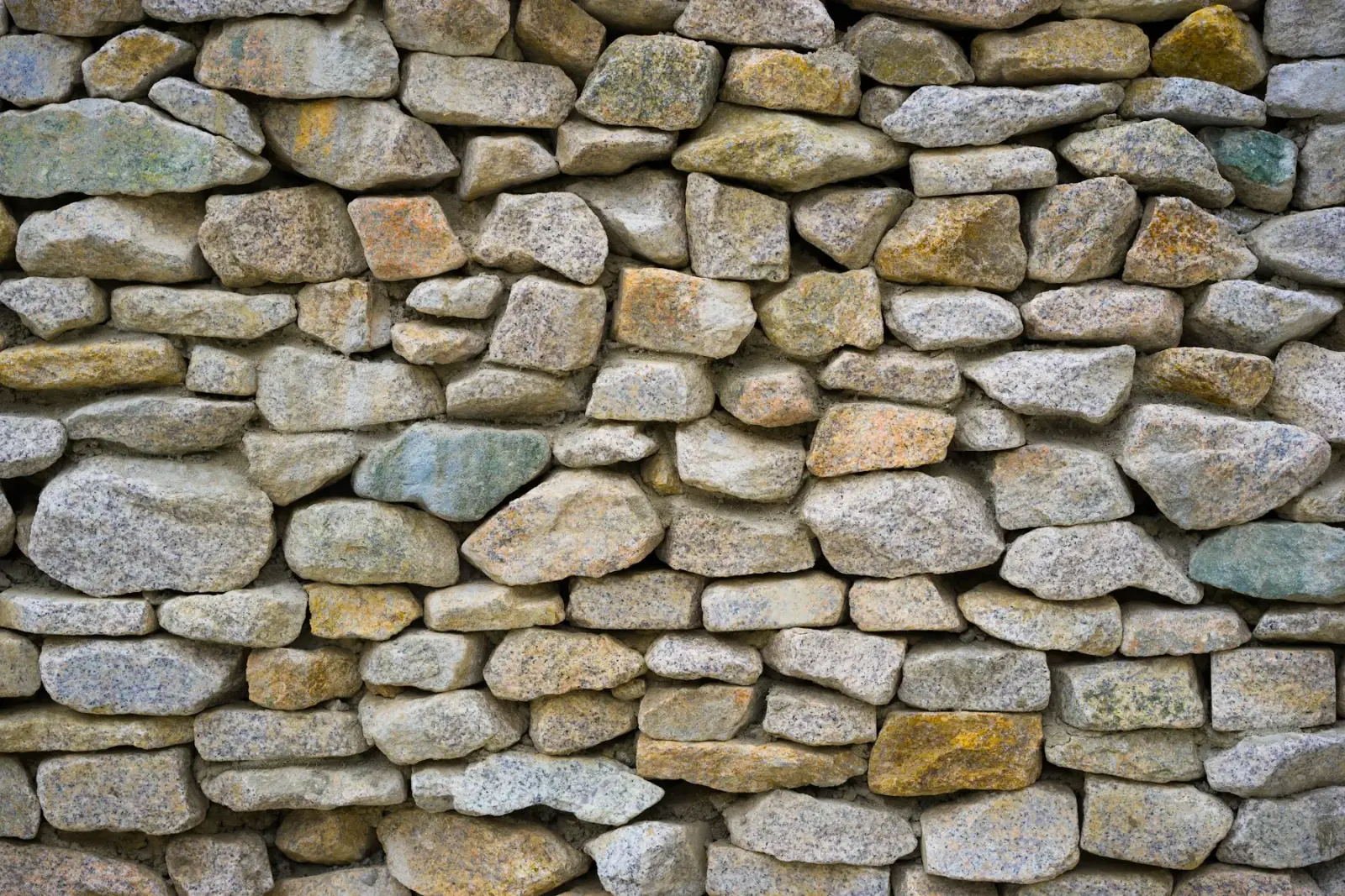 Mixed natural rock retaining wall for landscape terracing by MCG Top Masonry